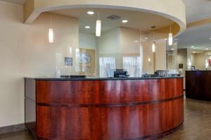 a lobby with a wooden counter in a salon at Comfort Suites Orlando Airport in Orlando