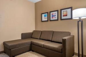 a living room with a couch and a lamp at Comfort Suites Orlando Airport in Orlando