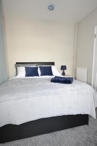 a bedroom with a large white bed with blue pillows at Townhouse @ Penkhull New Road Stoke in Stoke on Trent