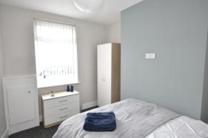 um quarto com uma cama, uma cómoda e uma janela em Townhouse @ Penkhull New Road Stoke em Stoke on Trent