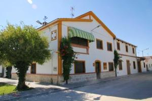 ein weißes Gebäude mit grüner Markise auf einer Straße in der Unterkunft 6 bedrooms house with enclosed garden at Ivanrey in Ciudad-Rodrigo