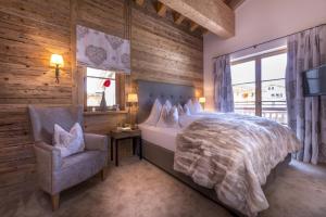 レッヒにあるCircle Chalets Arlbergのベッドルーム(ベッド1台、椅子、テレビ付)