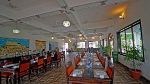 a restaurant with a long table with people sitting at it at The Lal Bagh in Kumbhalgarh