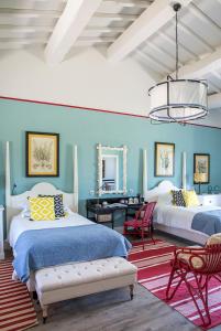 a blue bedroom with two beds and a desk at Locanda Rossa in Capalbio