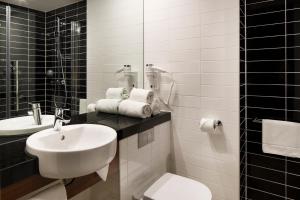 a bathroom with a sink, toilet and mirror at Holiday Inn Express Amsterdam - Sloterdijk Station, an IHG Hotel in Amsterdam