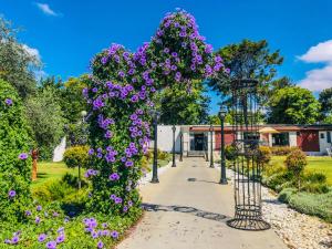 a garden with purple flowers on a pathway at Erettz Dafna Travel Hotel in Metsudat Menahem Ussishkin Alef