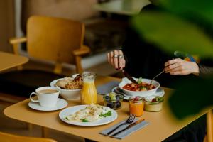 une personne assise à une table avec des assiettes de nourriture dans l'établissement PURO Kraków Stare Miasto, à Cracovie