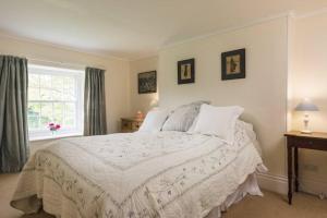 博德明的住宿－Manor and Farm House Sleeps 25，卧室配有白色的床和窗户。