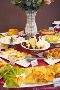stół wypełniony talerzami żywności i wazonem w obiekcie Pak Suítes Hotel w mieście Luis Eduardo Magalhaes