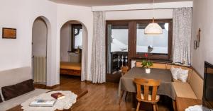 a living room with a table and a dining room at Residence Lärchenhäusl in Soprabolzano