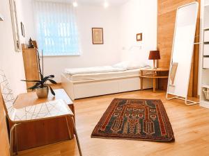 a bedroom with a bed and a rug on a wooden floor at Exquisites Übernachten in der ältesten Stadt Österreichs in Enns