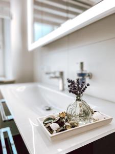 a bathroom counter with a sink and a vase of rocks at Exquisites Übernachten in der ältesten Stadt Österreichs in Enns