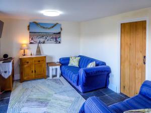 uma sala de estar com um sofá azul e uma mesa em Looe Self Catering em Looe