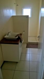 a small bathroom with a sink and a window at Shaquila Lodge in Fernão Veloso +20 photos