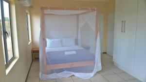 a bed with a canopy in a room at Shaquila Lodge in Fernão Veloso
