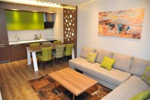 a living room with a couch and a table and a kitchen at Pansion Winter in Jahorina