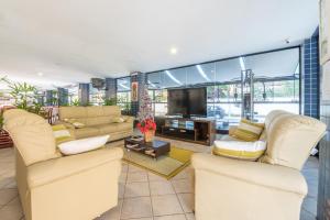 a living room with couches and a flat screen tv at OYO Residencial Itacuruçá Apart Hotel in Itacuruçá