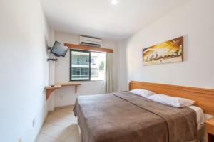 um quarto com uma cama e uma janela em OYO Residencial Itacuruçá Apart Hotel em Itacuruçá