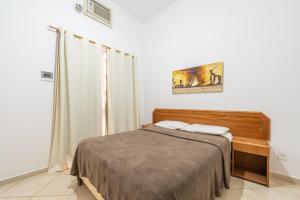 1 dormitorio con 1 cama en una habitación blanca en OYO Residencial Itacuruçá Apart Hotel en Itacuruçá