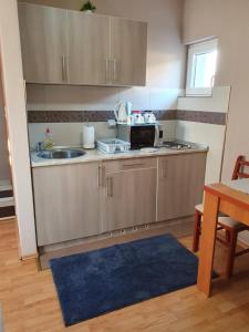 a small kitchen with a sink and a microwave at Apartman "MILLAN" in Prijedor