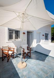 tenda bianca su un patio con sedie e tavolo di Giorgantis House & Studio a Triovasálos