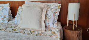 a bed with a blanket and pillows on it at Adore Portugal Bungalow Natureza & Vista de Serra in Lousã