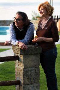 two women standing on top of a stone wall at B&B Villa Bency in Capo dʼOrlando