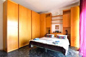 um quarto com armários de madeira e uma cama. em Das Karma - BRUZZI em Gênova