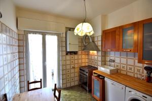 uma cozinha com uma mesa, um lavatório e uma janela em Das Karma - BRUZZI em Gênova