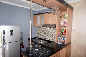 a small kitchen with a refrigerator and a stove at Safa Homestay in Yogyakarta