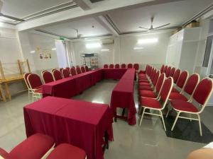 una sala de conferencias con mesas rojas y sillas rojas en Rich Hotel, en Can Tho