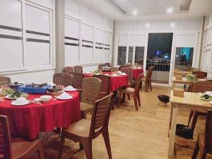 una sala da pranzo con tavoli e sedie con tovaglia rossa di Rich Hotel a Can Tho