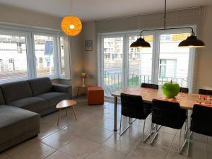 een woonkamer met een tafel en een bank bij Residentie Week-end Elisalaan in Nieuwpoort