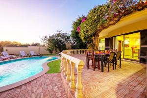un patio con mesa y sillas junto a una piscina en Villa Bantayan by Algarve Vacation, en Albufeira