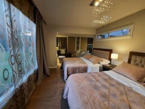 マル・デル・プラタにあるCasa Guemesのベッド2台とリビングルームが備わるホテルルームです。
