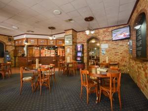 uma sala de jantar com mesas e cadeiras num restaurante em Albion Hotel em Kalgoorlie