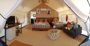 a living room with a bed and a couch at Mont Blanc Base Camp Khaoyai in Pak Chong