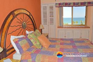 a bedroom with a large bed with a view of the ocean at Princesa C - 402 by FMI Rentals in Puerto Peñasco