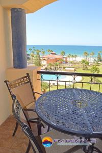 a table and chairs on a balcony with a view of the beach at Princesa C - 402 by FMI Rentals in Puerto Peñasco