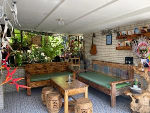 une chambre avec des bancs, une table et une guitare dans l'établissement Guest House Home 46 Bali, à Canggu