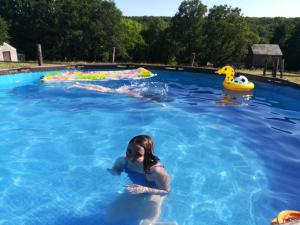 a young girl swimming in a swimming pool at Les Tramois in Donzy