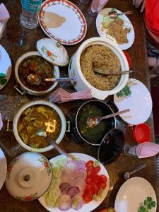 una mesa con muchos platos de comida. en Jewel Of Kashmir House Boat, en Nagīn Bāgh