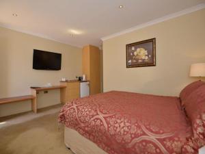 um quarto de hotel com uma cama e uma televisão de ecrã plano em The Tower Hotel em Kalgoorlie
