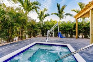 a swimming pool with a water fountain in a backyard with palm trees at Kompose Boutique Hotel Sarasota in Sarasota
