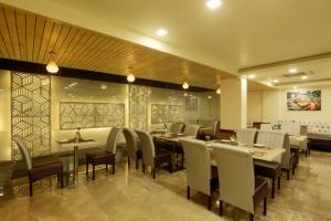 a dining room with tables and chairs in a restaurant at Hotel Omega - Gurgaon Central, Sec 45 in Gurgaon