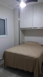 ein Schlafzimmer mit einem Bett in einem Zimmer mit einer Decke in der Unterkunft Vila Monrealle in Ubatuba