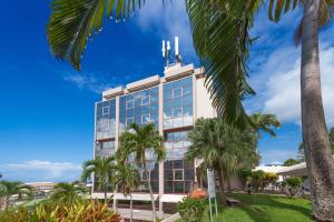 un edificio con palme di fronte di Karibea Squash Hôtel a Fort-de-France