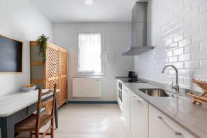 a white kitchen with a sink and a counter at Apartamento KUIA en el centro de Barakaldo al lado del metro in Barakaldo