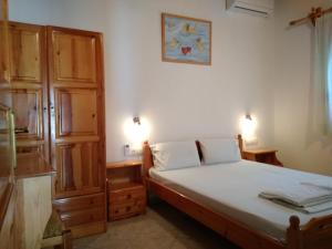 villa axiothea في مدينة سكياثوس: غرفة نوم صغيرة مع سرير وخزانة