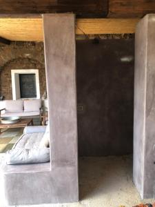 a concrete room with a bed and a couch at Dammuso Rekhale in Scauri